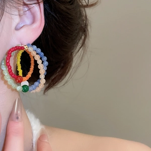 Close-up of colorful beaded hoop earrings with vibrant multi-colored resin stone detail