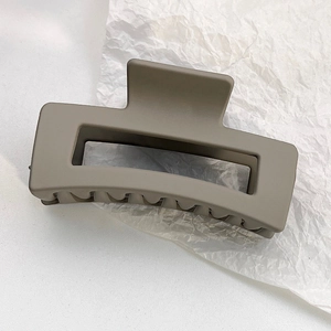 Close-up of matte milk tea colored rectangular hollow hair claw clip on white paper