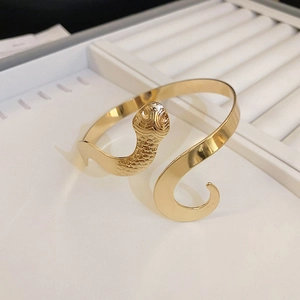 Détail d'un bracelet serpent doré avec texture d'écailles et conception ouverte réglable