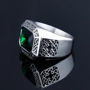 Macro view of vintage stainless steel ring with emerald green stone and Celtic carvings