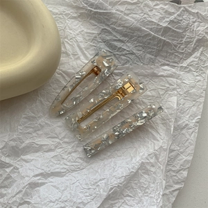 Three transparent acrylic hair clips with silver foil flakes and gold metal base detail