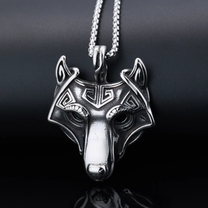 Detailed close-up of antique silver wolf head pendant with intricate metallic textures