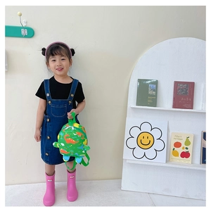 Toddler girl wearing a green plush dinosaur backpack with cute prints for school