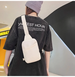 Detailed back view of off-white minimalist nylon chest bag with adjustable strap on model