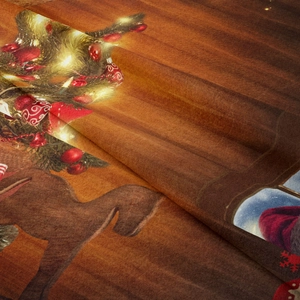 Close-up of soft plush fabric with festive Christmas tree and reindeer print patterns