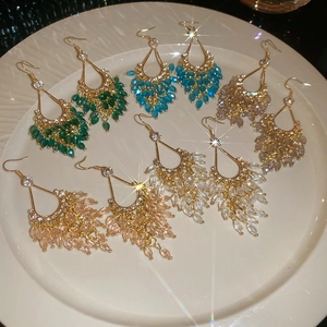 Close-up of Bohemian drop fringe earrings with colorful crystal beads in gold frames