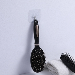 Ergonomic black and gold anti-static hair brush set hanging on wall for home styling