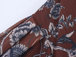Close-up of reddish-brown floral chiffon fabric with vertical texture and vintage prints