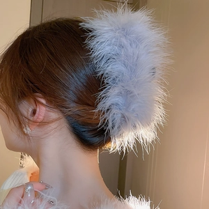 Close-up of fluffy light blue feather hair claw clip used in a stylish bun hairstyle