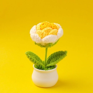 Detail of handcrafted crochet rose with yellow petals in a white ceramic pot