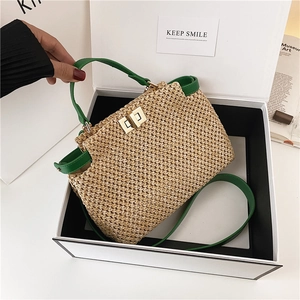 Retro straw handbag with green leather trim and golden clasp in a gift box view