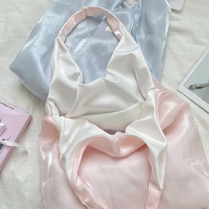 Detail of pink satin tote bag with silky texture and thickened piping on shoulder strap