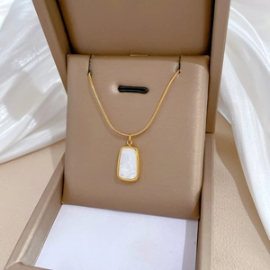 Gold titanium steel snake chain necklace with square shell pendant in a beige jewelry box