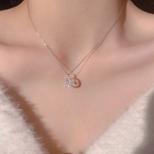 Minimalist titanium steel crescent moon and star pendant necklace on model with soft focus