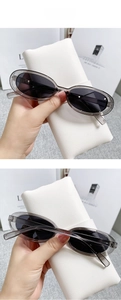 Detail view of oval grey frames and dark grey lenses on stylish cat eye sunglasses