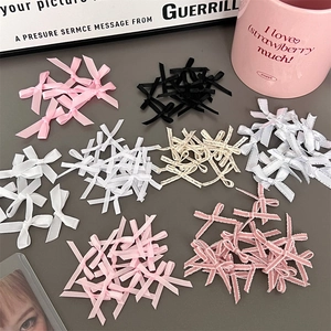 Close-up of colorful satin ribbon bows in pink, black and white for DIY gift packing