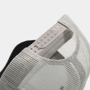 Macrodetail van de verstelbare snapback-sluiting en ademend mesh van een truckerpet