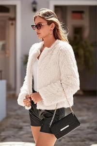 Detail view of white faux fur coat texture with plush long-hair finish for autumn fashion