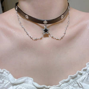 Close-up of black leather choker with star rhinestone pendant and silver chains