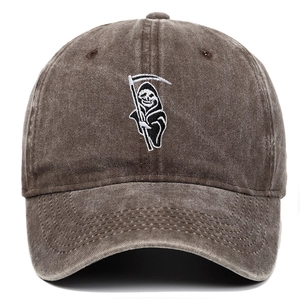 Detail of reaper embroidery on brown washed cotton baseball cap with vintage distressed finish