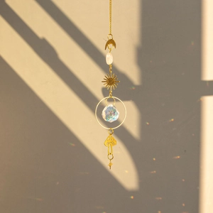 Brass butterfly suncatcher detail with crystal ball casting colorful rainbow light