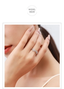 Macro detail of S925 silver daisy ring with white zircon stones on model finger