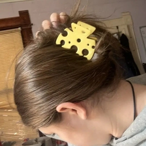 Creative hollow cheese hair claw clip on dark brown hair for unique ponytail styling