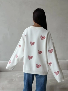 White loose knit sweater with red heart patterns shown from a back view silhouette
