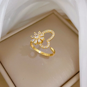 Macro shot of gold adjustable ring featuring a heart frame and zircon sunflower design