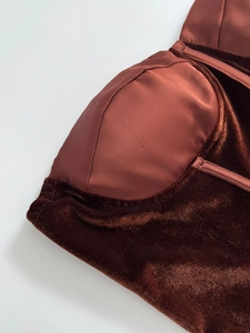 Detail of velvet and satin corset top featuring luxury bustier stitching and bone structure