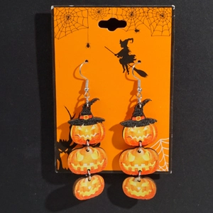 Halloween wooden pumpkin earrings with black wizard hats on decorative card backdrop