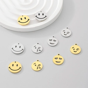 Macro shot of stainless steel emoji smile pendants in gold and silver finishes