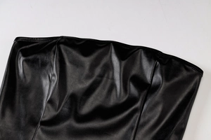 Detail der glänzenden schwarzen Kunstleder-Struktur am figurbetonten Kleid