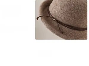 Detailed view of the wool bucket hat brim with brown leather cord and metal buckle accent