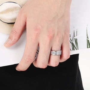 Detail of a vintage silver stainless steel ring with diamond grid pattern worn on finger