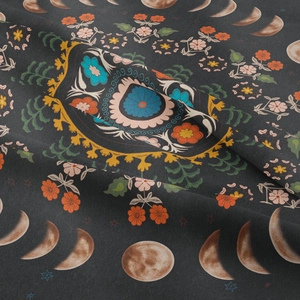 Macro detail of Bohemian tapestry showing phases of the moon and floral patterns