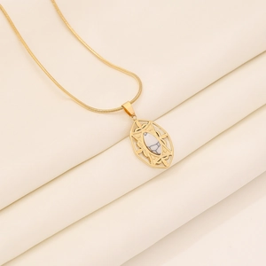 Vintage gold stainless steel necklace featuring an oval marble stone pendant on beige fabric