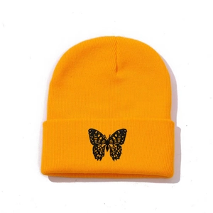 Detailed view of orange knit beanie featuring black butterfly embroidery on the cuff