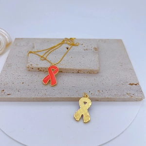 Detail of red ribbon pendants with gold plating and cubic zirconia on stone base