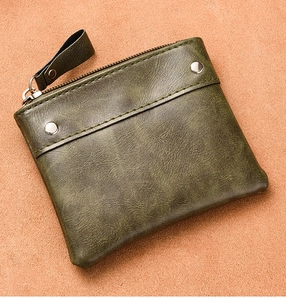 Detail view of dark green pebbled leather coin purse with silver rivets and metal zipper
