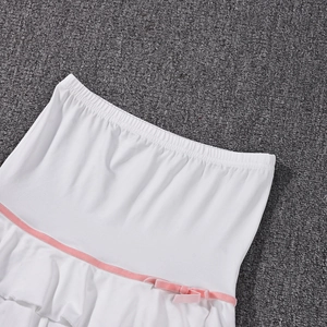 Detail of white cotton mini skirt featuring elastic waist and pink decorative ribbon bow