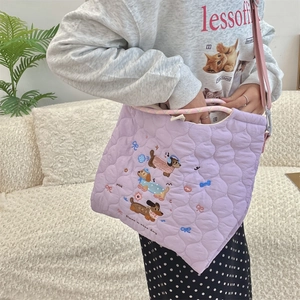 Close-up of cute dog embroidery and quilted texture on a purple cotton tote bag