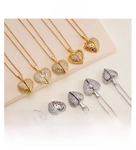 Close-up of heart-shaped pendants with pave zircon and filigree details in gold and silver