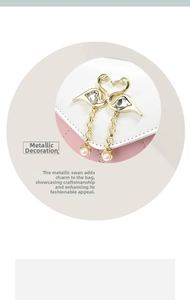 Detail of pink and white crossbody bag featuring golden swan hardware and pearl charms