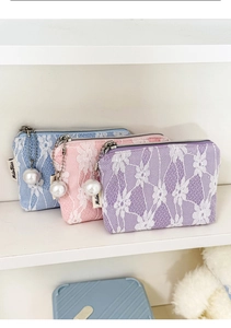 Detailed view of lace mini pouches with pearl charms in blue, pink, and purple colors