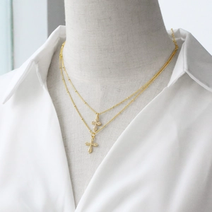 Elegant 18k gold plated double layer cross pendant necklace for women on a mannequin