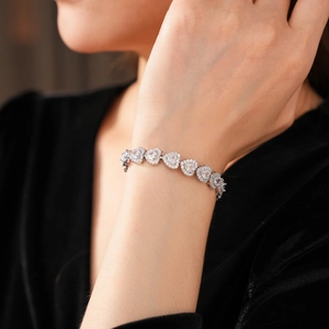 Close-up of sparkling heart zircon bracelet in silver finish on a model's wrist