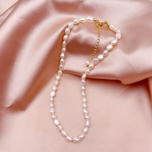Elegant natural baroque pearl necklace with 14k gold-filled clasp on pink silk