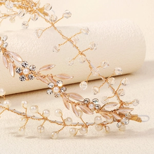 Macro detail of handmade bridal headband with gold leaves, pearls and crystal beads