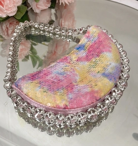 Macro detail of colorful sequin evening bag with crystal rhinestones on a mirror